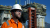 Engineer in hard hat standing in front of the Argos platform, which is under construction